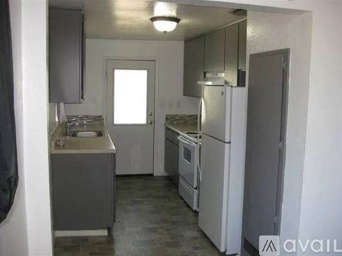 A small kitchen with a sink, stove, and refrigerator.
