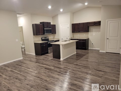 A kitchen with dark brown cabinets and a white island.