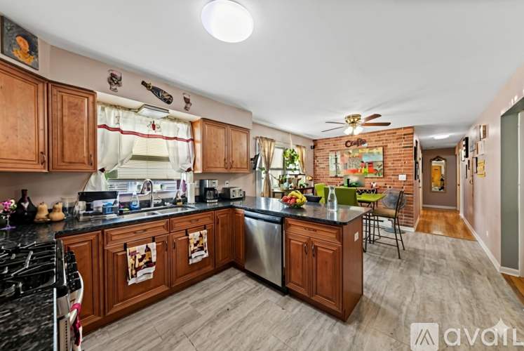 A kitchen with wooden cabinets and a black countertop.