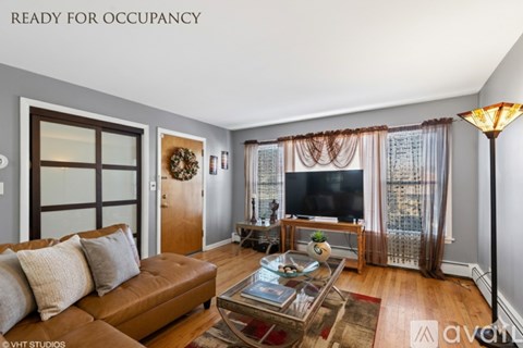 A living room with a brown leather couch and a glass coffee table.