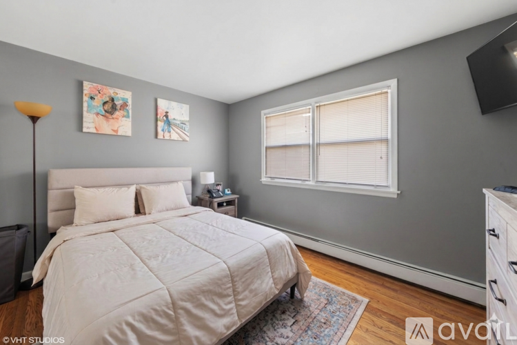 A bedroom with a large bed and a window.