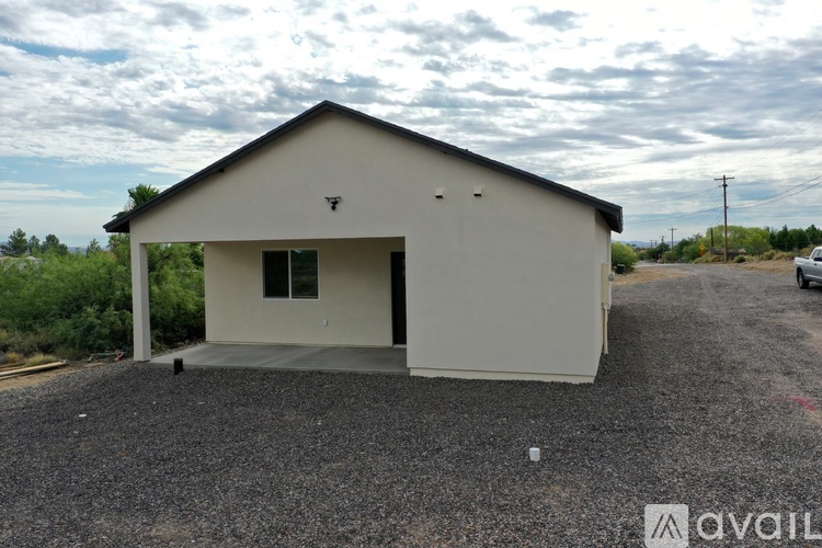 A small white building with a gravel driveway in front.