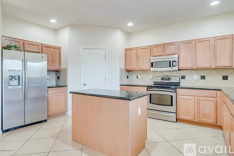 A kitchen with wooden cabinets and a black countertop.