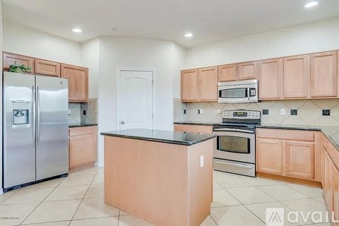 A kitchen with wooden cabinets and a black countertop.