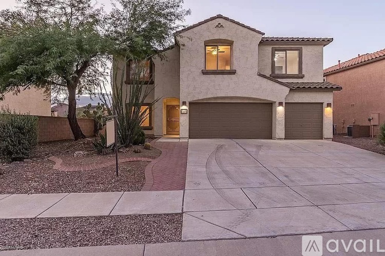 A house with a driveway and a tree in front of it.