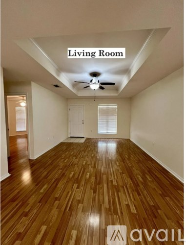 A living room with wooden floors and a ceiling fan.