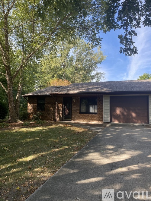 A house with a garage and a driveway in front of it.