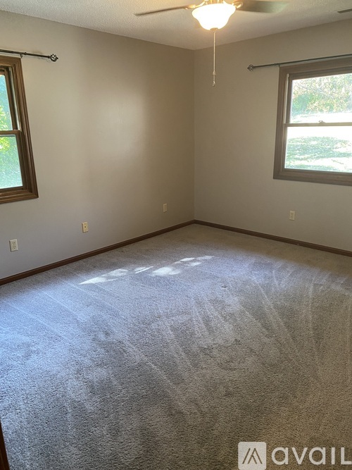 A room with a carpeted floor and a window.