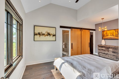 A bedroom with a large bed and a painting on the wall.