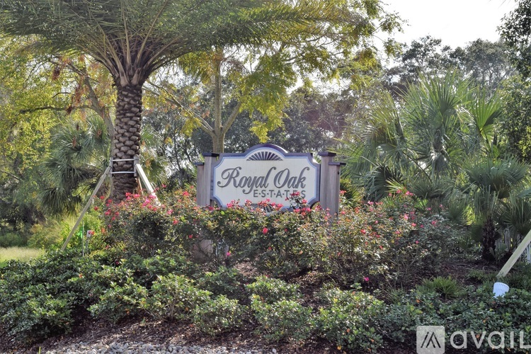 A sign for Royal Oak Estates is surrounded by greenery.
