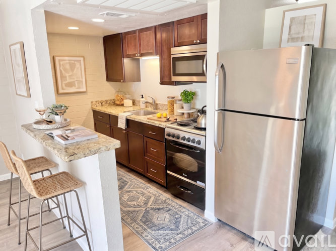 A kitchen with a refrigerator, oven, and sink.