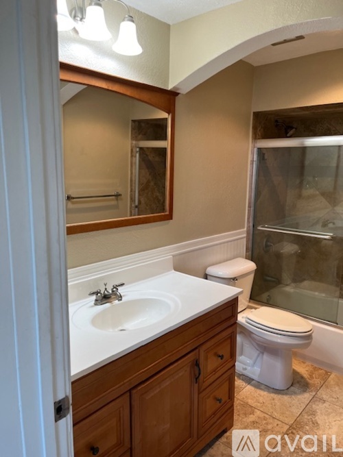 A bathroom with a sink, toilet, and mirror.