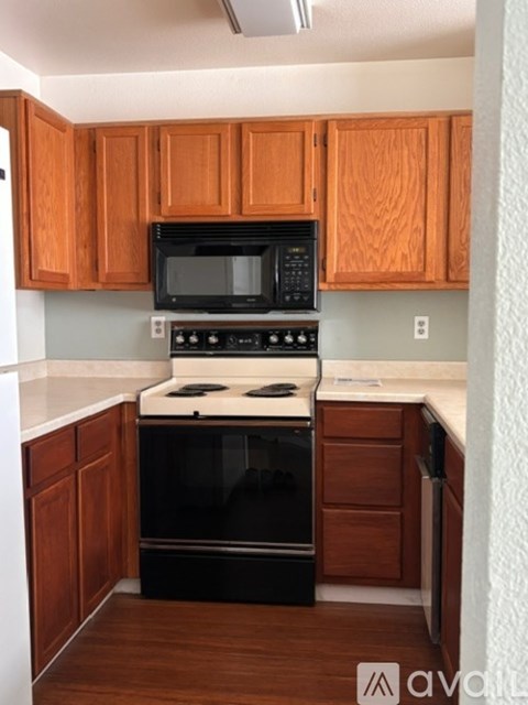 A kitchen with wooden cabinets and black appliances.