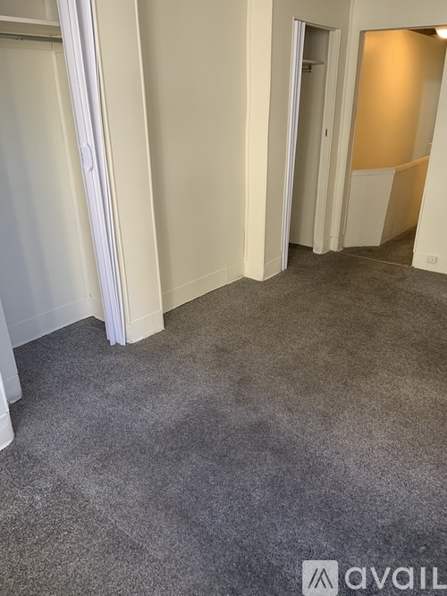 A carpeted hallway with a door on the right.