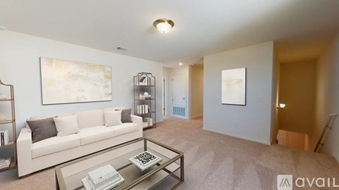 A living room with a white couch and a glass coffee table.