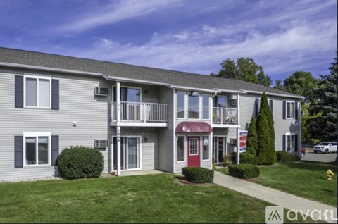 A two-story building with a red door and a balcony on the second floor.