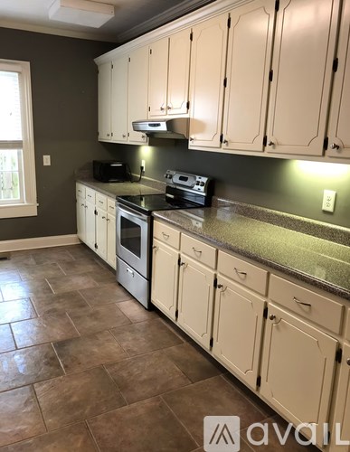 A kitchen with white cabinets and a granite countertop.