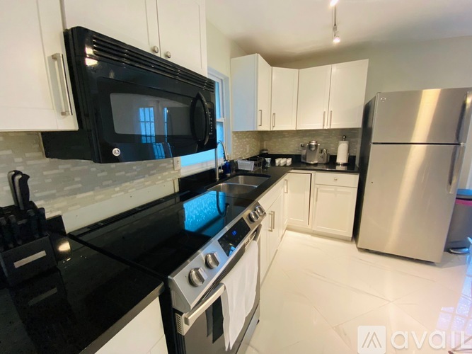A kitchen with black countertops and white cabinets.