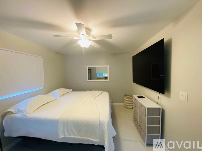 A bedroom with a bed, dresser, and television.