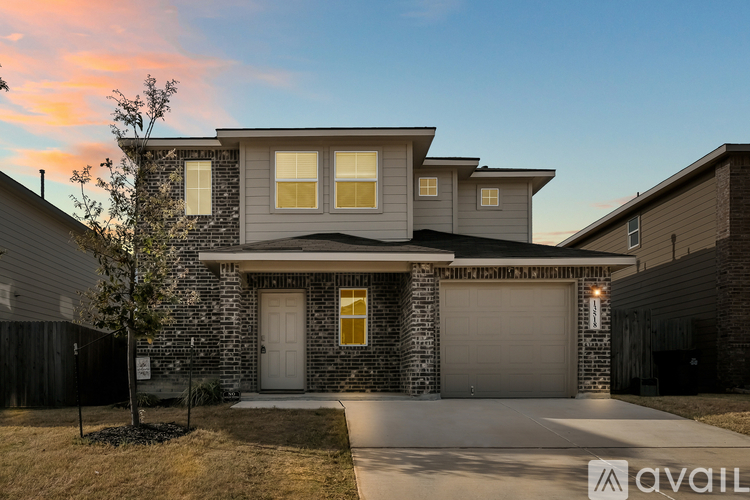 A house with a garage and a driveway in front of it.