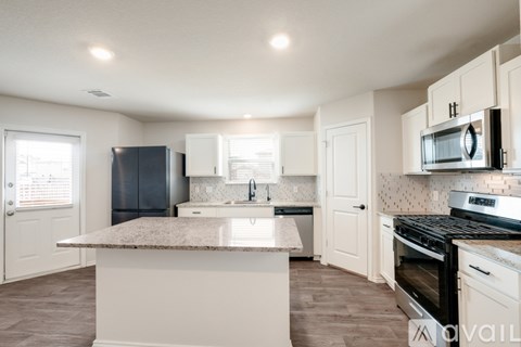 A kitchen with a granite countertop and stainless steel appliances.