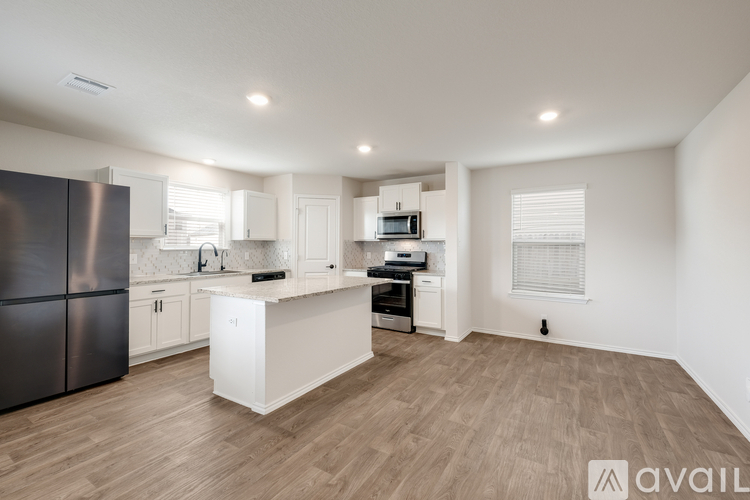 A modern kitchen with stainless steel appliances and white cabinetry.