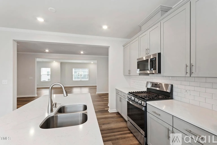 A modern kitchen with a stainless steel sink and oven.