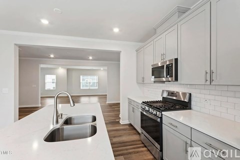 A modern kitchen with a stainless steel sink and oven.