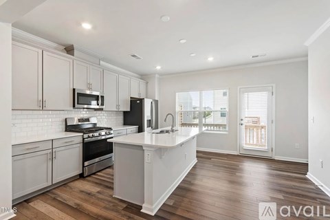A kitchen with white cabinets and a white island.