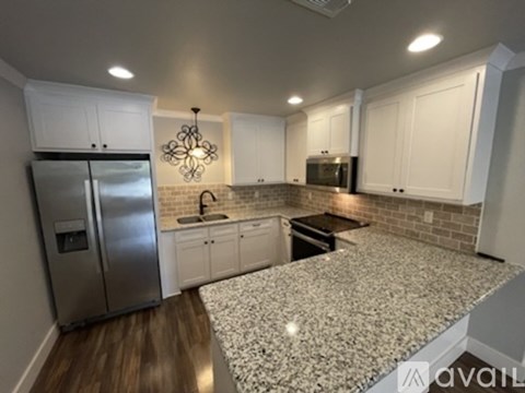 A kitchen with a granite countertop and stainless steel appliances.