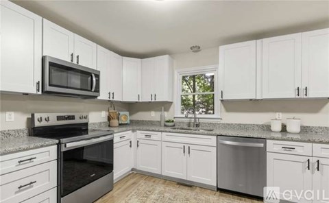 A kitchen with white cabinets and a granite countertop.
