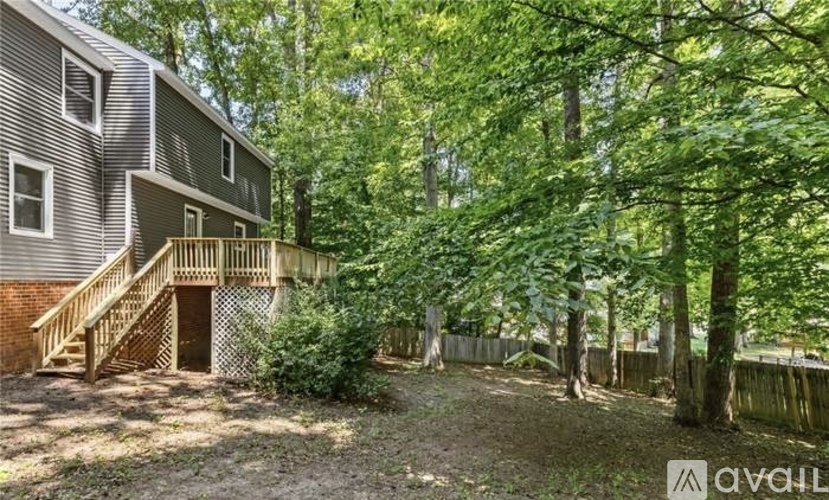 A house with a deck and trees in the backyard.