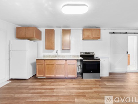 A kitchen with wooden cabinets and a white refrigerator.
