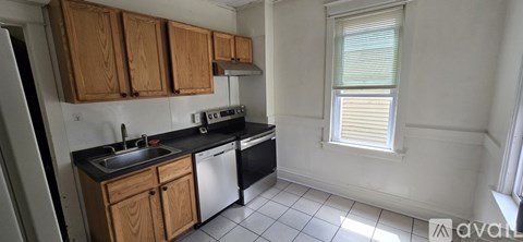 A kitchen with wooden cabinets and black countertops.