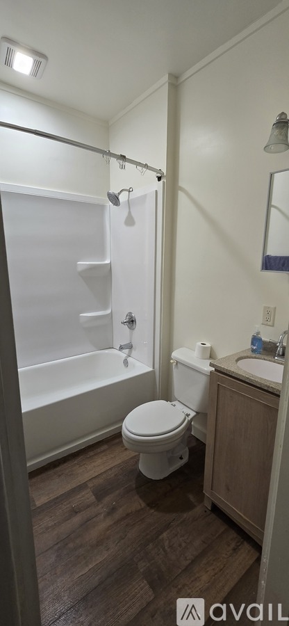 A bathroom with a toilet, sink, and shower.