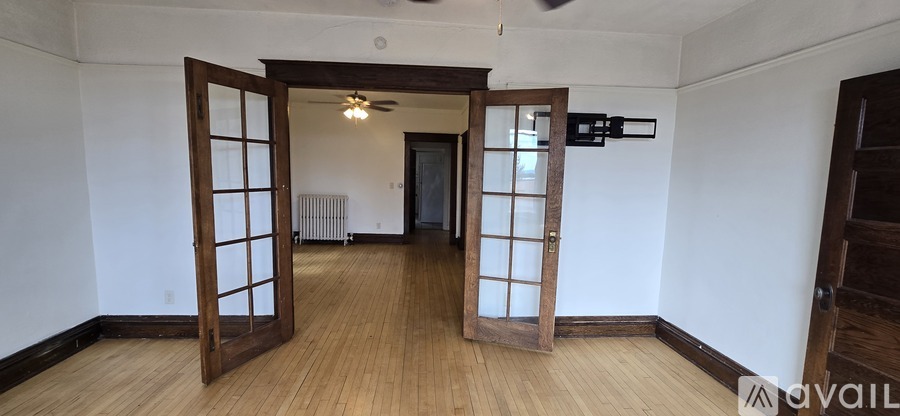 A room with a wooden floor and a ceiling fan.