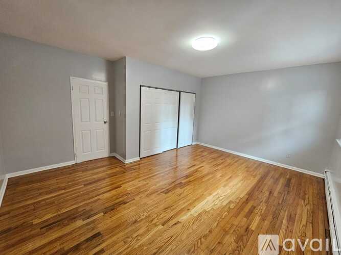 A room with wooden flooring and a white door.