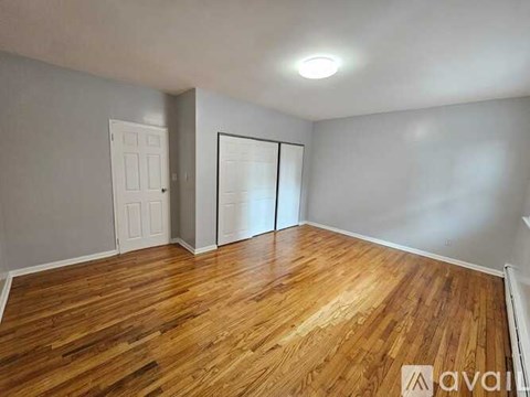 A room with wooden flooring and a white door.