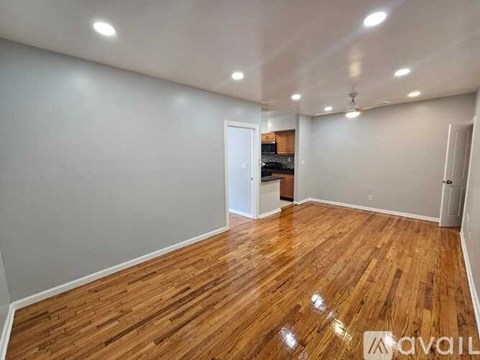 A room with wooden flooring and white walls is available for rent.