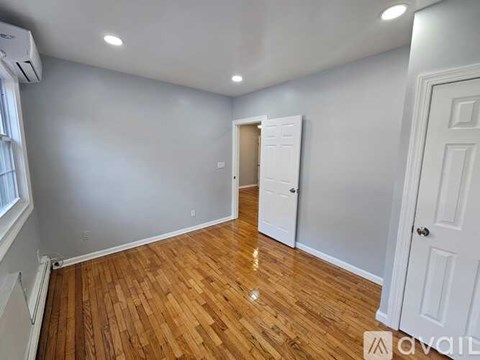 A room with wooden flooring and white walls.