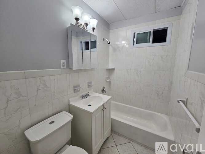 A white bathroom with a toilet, sink, and bathtub.