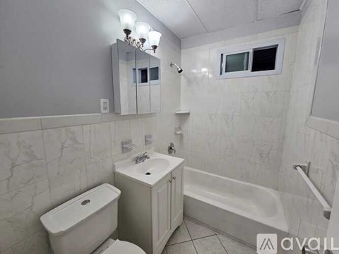 A white bathroom with a toilet, sink, and bathtub.