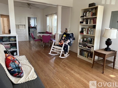 A living room with a grey sofa and a white rocking chair.