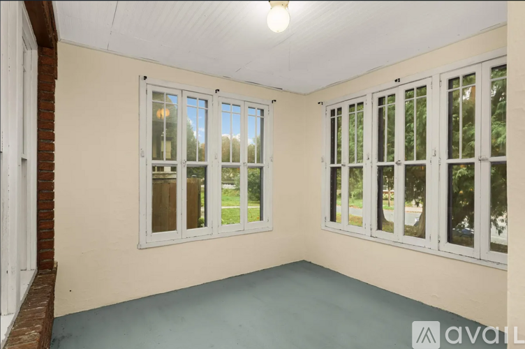 A room with a brick wall and a window with a view of trees.