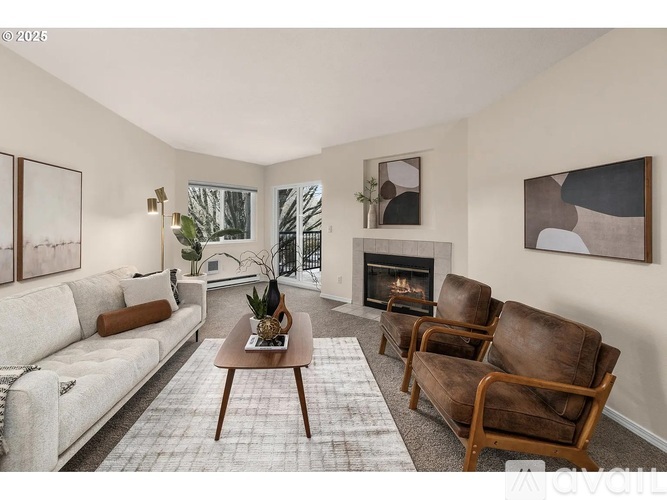 A living room with a fireplace, two chairs, and a couch.