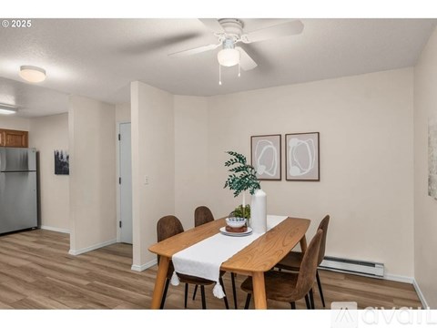 A dining room with a wooden table and chairs.
