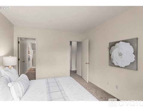 A bedroom with a large bed and a painting on the wall.