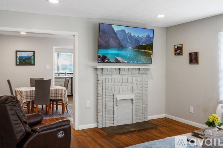 A living room with a fireplace and a television displaying a mountain landscape.