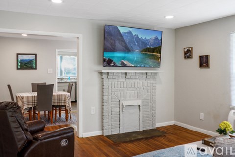 A living room with a fireplace and a television displaying a mountain landscape.