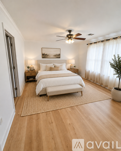 A bedroom with a large bed and a ceiling fan.
